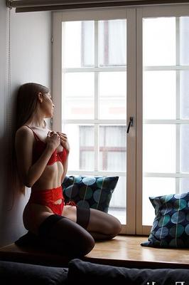 Evelina na janela de lingerie vermelha