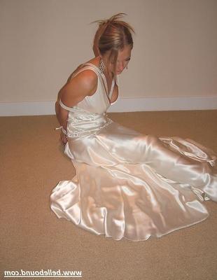 Charlie Dee amarrado em vestido branco de cetim